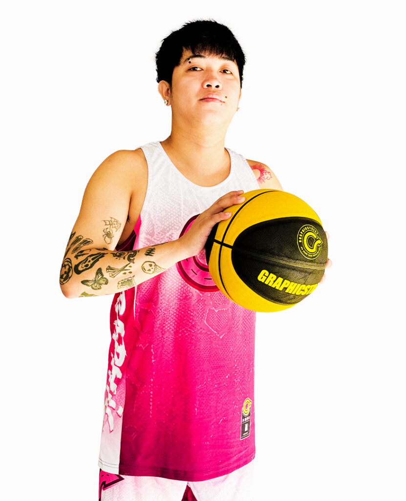 Home A model showcasing a Graphicstreet pink and white custom basketball jersey, holding a Graphicstreet branded basketball, highlighting the apparel and sports equipment.